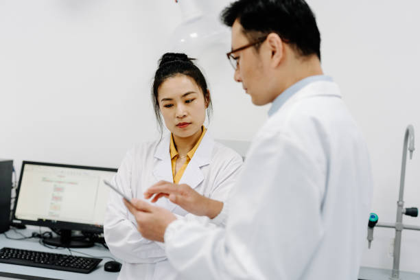 istock Two Asian scientists discussing on digital tablet in laboratory. 2183623340