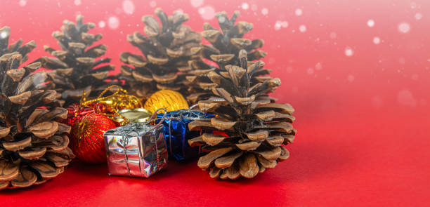 istock Festive pine cones and gift boxes on a red Christmas background 2183629655