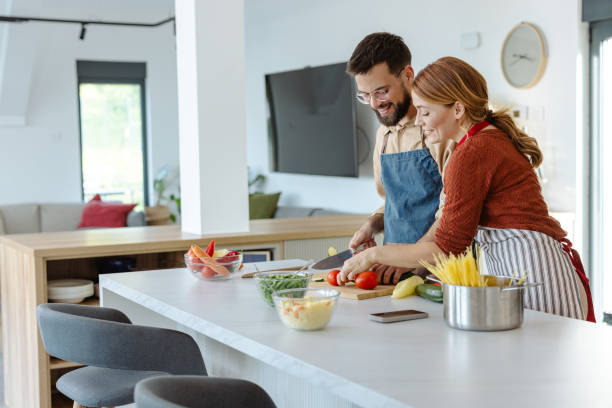 istock Couple preparing meal together in modern kitchen setting 2183632803