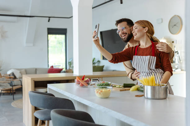 istock Couple cooking together and taking a selfie in modern kitchen 2183632930