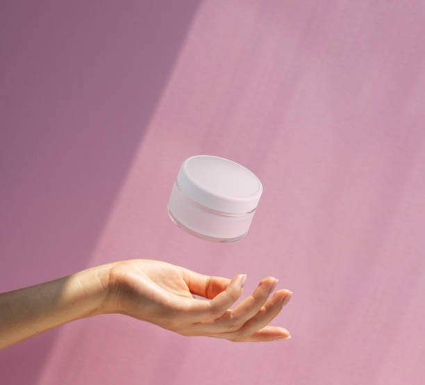 istock hand holding a  jar of cream on a pink background 2183633718