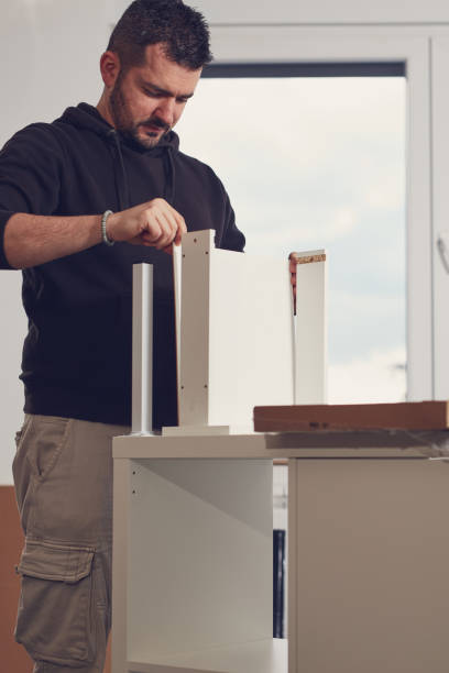 istock Man working and assembling furniture in a new apartment. 2183636964