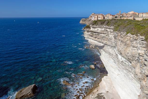 Historic Bonifacio on Corsicas dramatic limestone cliffs against a clear blue Mediterranean sea and sky in summer