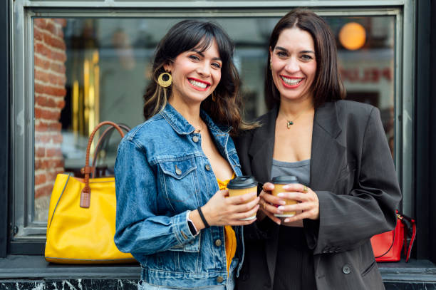 istock Two young women drinking coffee on the street 2183642752