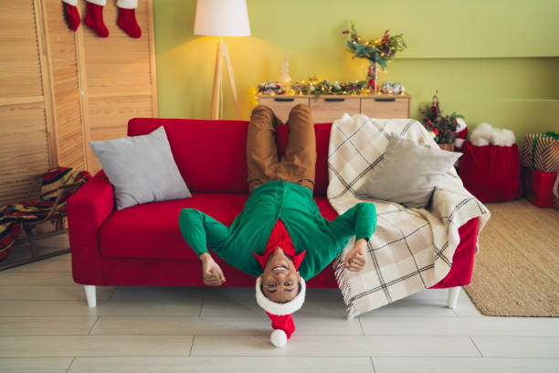 Photo of funky lucky guy dressed green cardigan rising fists enjoying x-mas day indoors house apartment room Photo of funky lucky guy dressed green cardigan rising fists enjoying x-mas day indoors house apartment room. black hat upside down stock pictures, royalty-free photos & images
