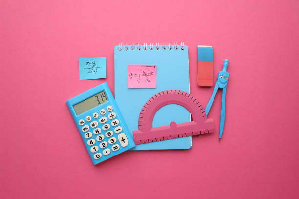 Stationery calculator ruler calculator and school cheat sheets on coloured background. Concept of school and college learning.