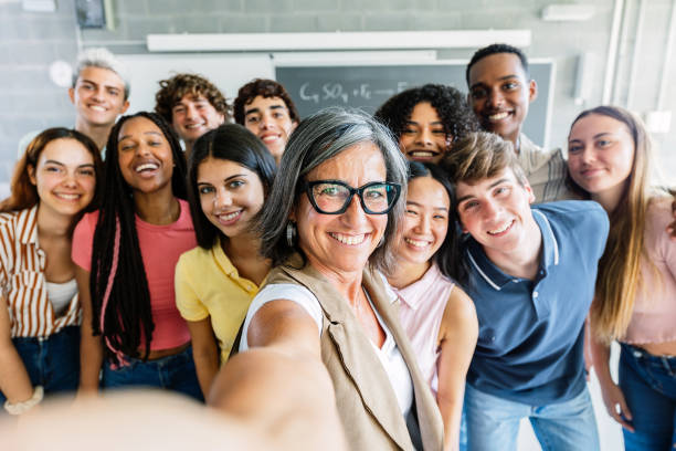 istock Multiracial high school student friends taking selfie with teacher in class 2183645928