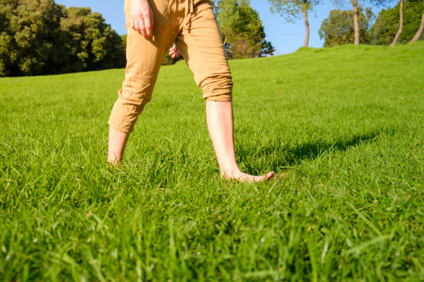 istock Woman walking on the grass barefoot. grounding / earthing 2183646056