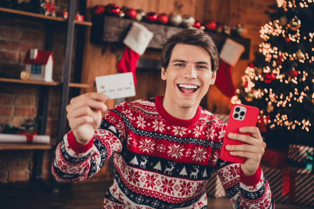 istock Photo of cheerful positive guy dressed ornament pullover enjoying x-mas eve ordering presents modern gadget indoors house apartment room 2183646315
