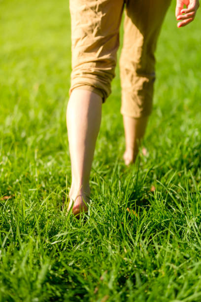 istock Woman walking on the grass barefoot. grounding / earthing 2183646658