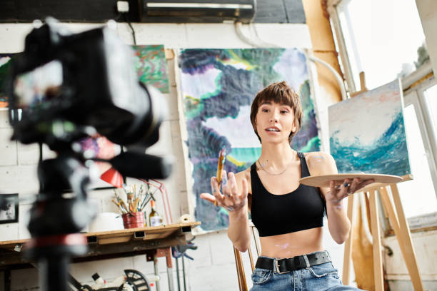 istock Creative young woman painting in an artistic studio while sharing her passion with a camera 2183646660