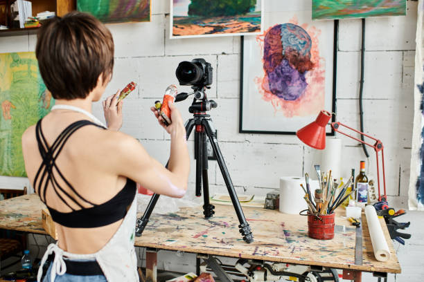 istock A young woman capturing her artistic process in a vibrant studio filled with colorful artwork 2183646715