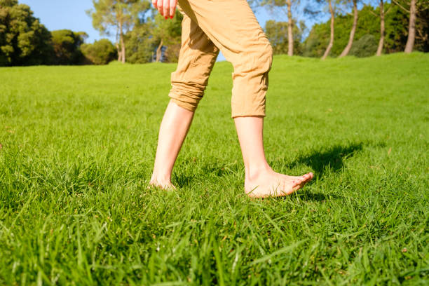 istock Woman walking on the grass barefoot. grounding / earthing 2183646730