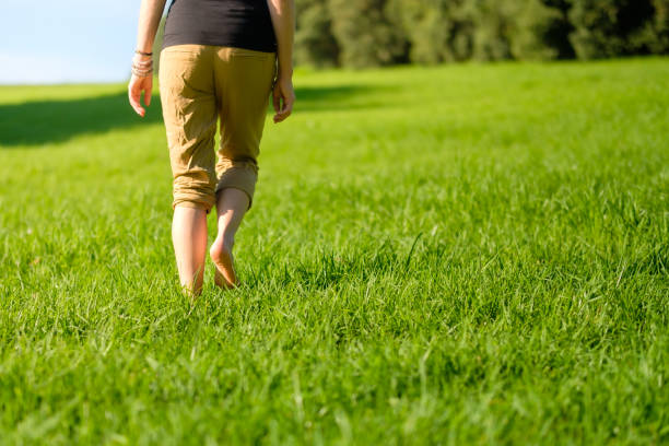 istock Woman walking on the grass barefoot. grounding / earthing 2183646794