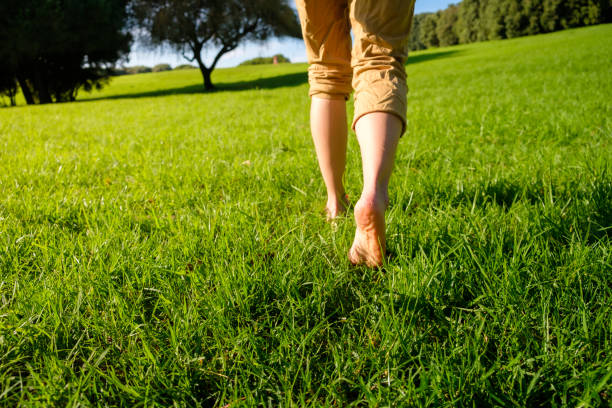 istock Woman walking on the grass barefoot. grounding / earthing 2183647168