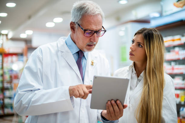 istock Pharmacists using digital tablet in pharmacy discussing about medicine 2183647346