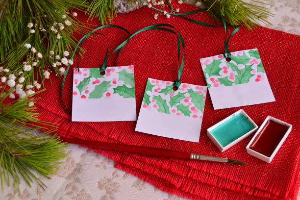 istock Christmas mistletoe holidays activity gift tags making green leaves red berries watercolor painting holly eve theme 2183647478