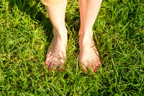 istock Woman standing in nature barefoot. grounding / earthing 2183647601