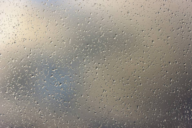 Window glass covered with very small fine raindrops macro as background