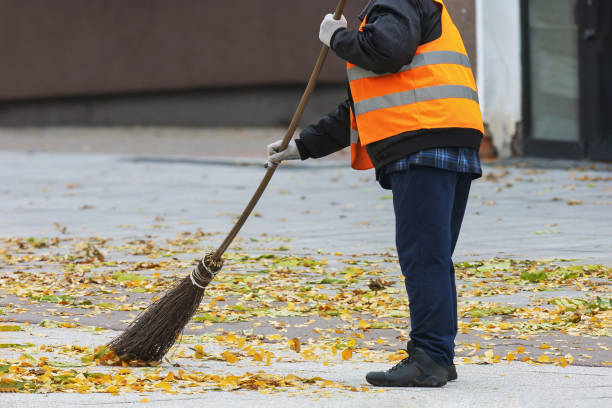 istock A worker sweeps autumn leaves in the town square 2183649062