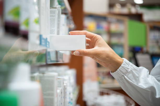 istock Pharmacist picking medicine box from pharmacy shelf 2183649156