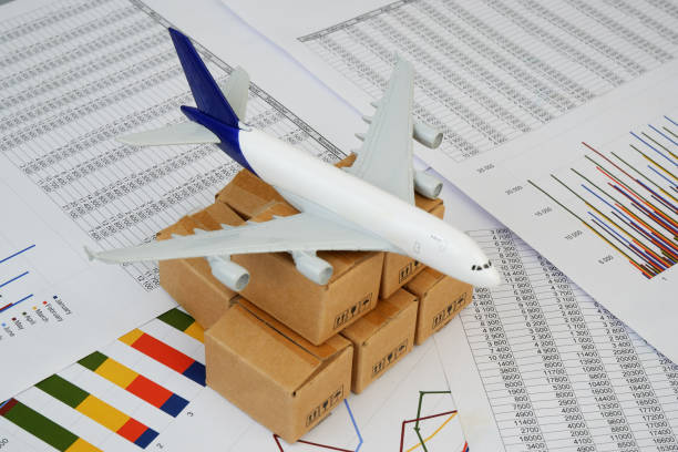 istock Airplane model and shipping carton boxes on financial documents close up. 2183657211