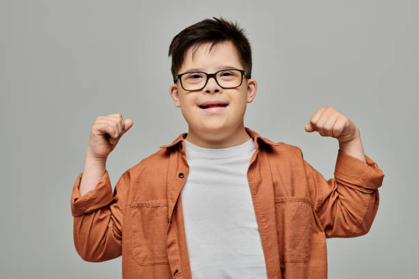 Joyful boy with Down syndrome expressing strength and happiness in a playful indoor setting