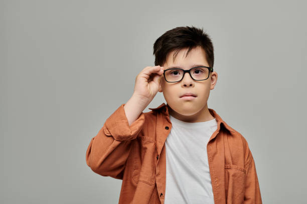 istock A thoughtful boy with Down syndrome wearing glasses in a cozy indoor setting 2183663086