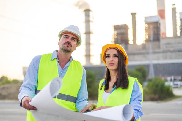 istock Engineers analyzing blueprints in front of power plant 2183665760