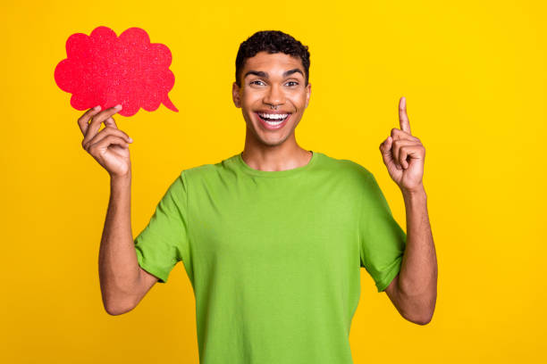 istock Portrait of funny creative handsome guy point finger hold empty space cloud shape card isolated on yellow color background 2183669878