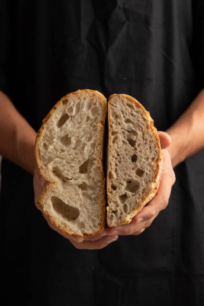 istock Freshly baked artisan bread held in baker's hands. 2183672499