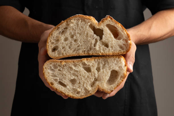 istock Freshly baked artisan bread held in baker's hands. 2183672507