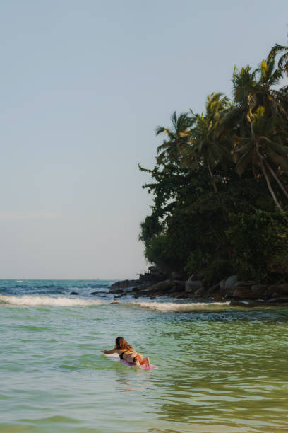 istock Woman surfing on Sri Lanka at sunset 2183673569