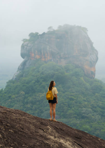 istock Woman looking with awe at clouds gathering above Sigiria rock 2183673778