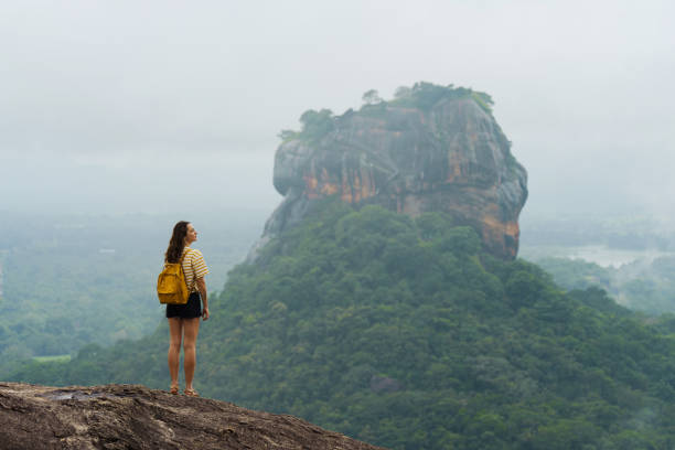 istock Woman looking with awe at clouds gathering above Sigiria rock 2183673783