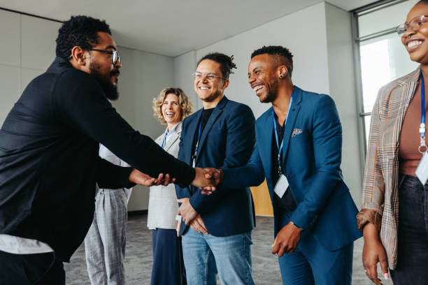 istock Diverse professionals in a corporate office greeting each other with a handshake 2183680017