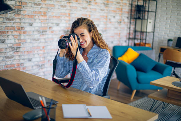 istock Young woman watching online live tutorial to learn how to use a photo camera 2183686369