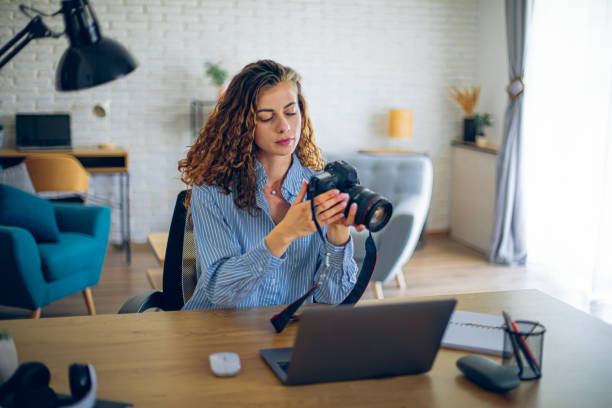istock Young woman watching online live tutorial to learn how to use a photo camera 2183687305