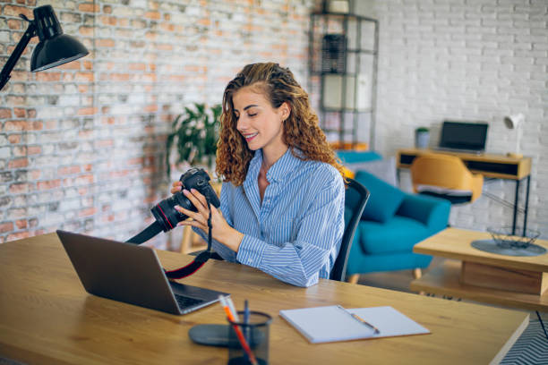 istock Young woman watching online live tutorial to learn how to use a photo camera 2183687323