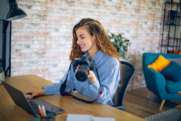 istock Young woman watching online live tutorial to learn how to use a photo camera 2183687452
