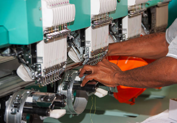 istock embroidery machine multiple head industrial, african american worker in a apparel textile factory 2183688371
