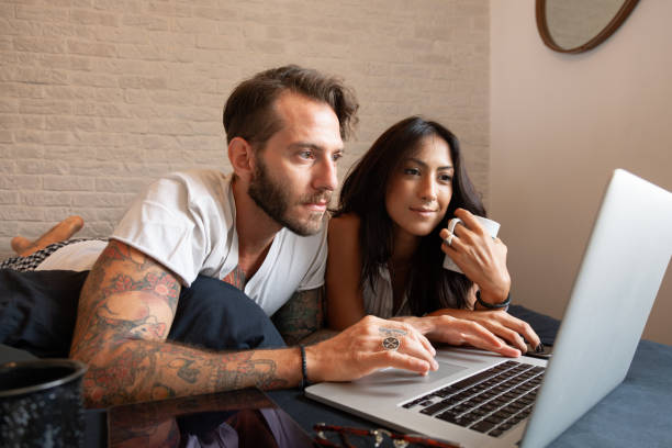 istock Couple in bed using a laptop and drinking coffee 2183689684