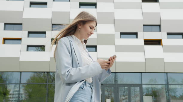 istock Business woman using smartphone texting female executive checking emails browsing messages on mobile phone. Business. Social Network. Apps. Career people. Shooting on the street near the office 2183692217