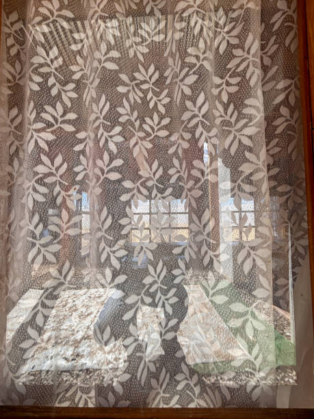 istock A window with a lace curtain is open, letting in the sunlight 2183696605