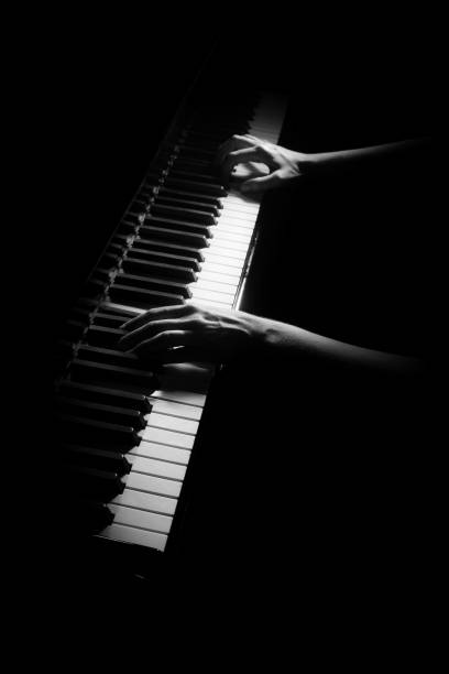 istock Piano player. Pianist hands playing keyboard isolated on black 2183703945
