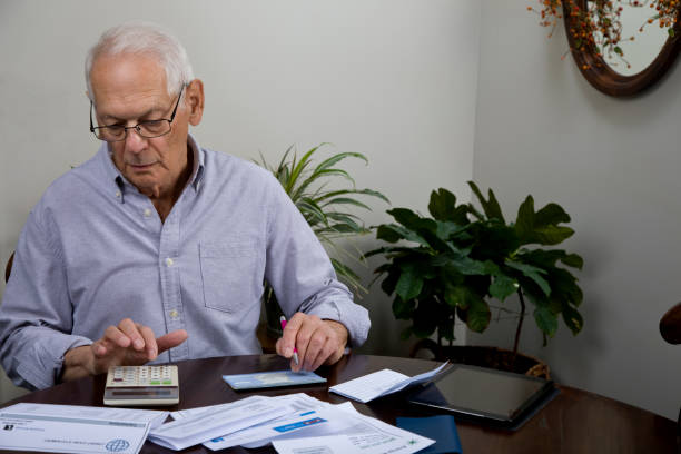 istock Senior man paying bills at home calculating payment 2183704731