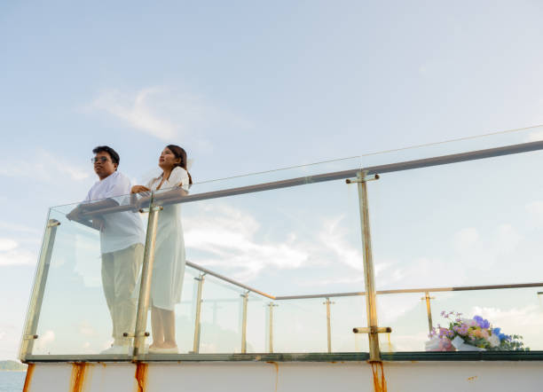 istock Joyful Asian bride and groom share a romantic moment outdoors, basking in the sunlight sky with scenic view. Their love and happiness radiate, beautiful wedding day and celebration of romance. 2183706245
