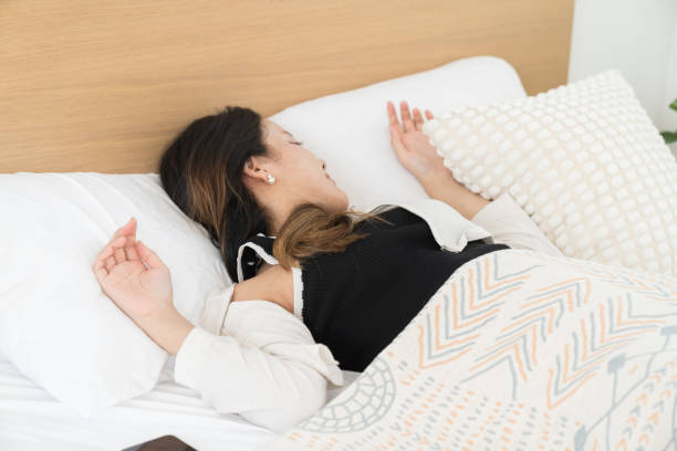 istock Young Asian woman sleeping on bed and keeping eyes closed while covered with blanket in bedroom. Asian woman sleep and lying on bed in bedroom in the morning. Healthcare concept 2183708167