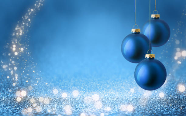 istock Christmas tree baubles on shiny glitter blue background with bokeh light. Festive winter holiday decoration and ornament. 2183710982
