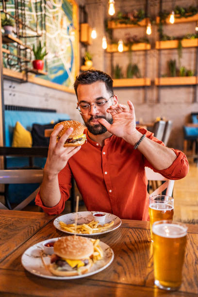 istock Young man enjoying a delicious burger 2183714633